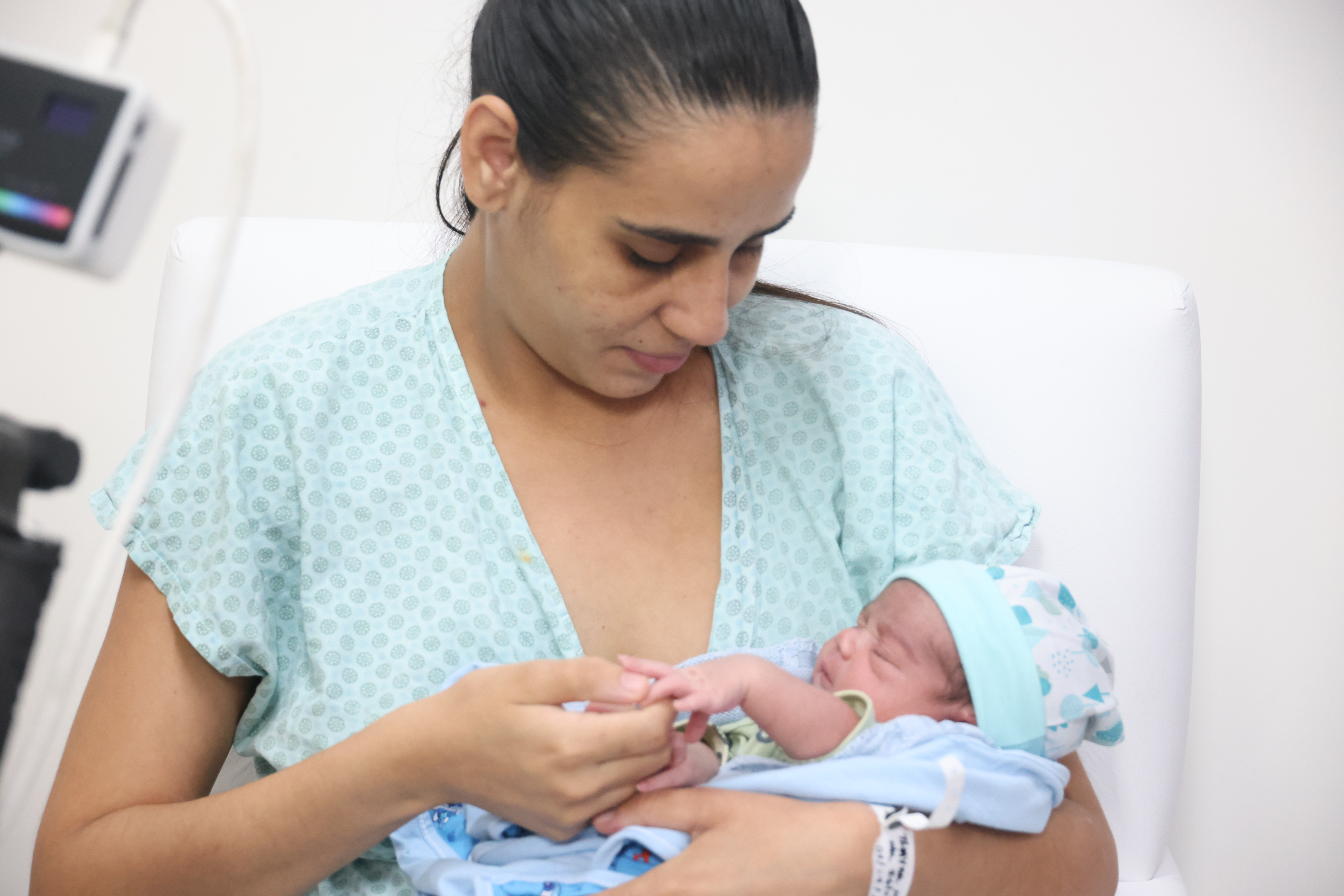 Uma mulher segura uma bebê no colo
